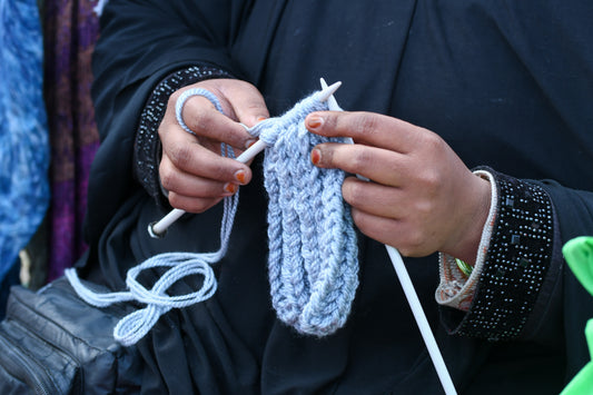 Hands knitting with needles and yarn